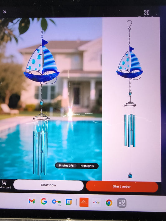 Coastal Sailboat Wind Chime. It features a blue and white sailboat topper.